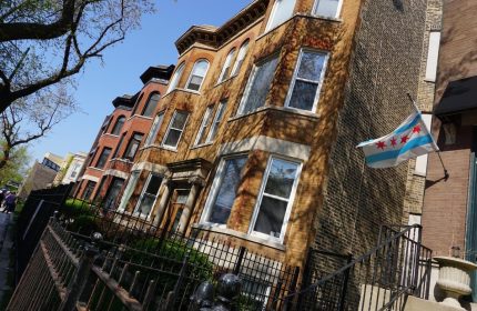 Wrigley Hostel, an adults-only, gay-friendly hotel in Chicago. View of the building's exterior with a Chicago flag waving.