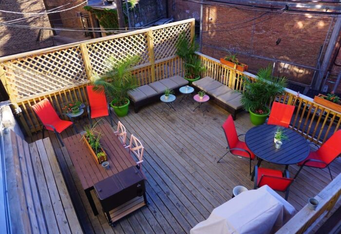 Wrigley Hostel's outdoor patio. This gay-friendly adults-only hotel features a rooftop deck with tables, chairs, and lounge furniture for relaxing.