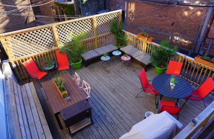 Wrigley Hostel's outdoor patio. This gay-friendly adults-only hotel features a rooftop deck with tables, chairs, and lounge furniture for relaxing.