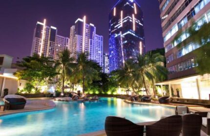 Wyndham Casablanca Jakarta gay-friendly hotel pool at night. Jakarta skyline view. Gay travel in Indonesia.