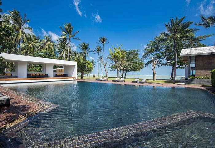 X2 Koh Samui, a gay-friendly spa retreat. Pool, lounge area, palm trees, and ocean view. Ideal for gay travel and relaxation in Thailand.