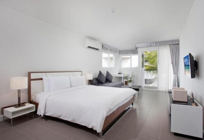 X2 Vibe Phuket Patong room. Gay-friendly hotel bedroom with a bed, sofa, TV, and balcony. Modern design, perfect for gay travelers in Phuket.