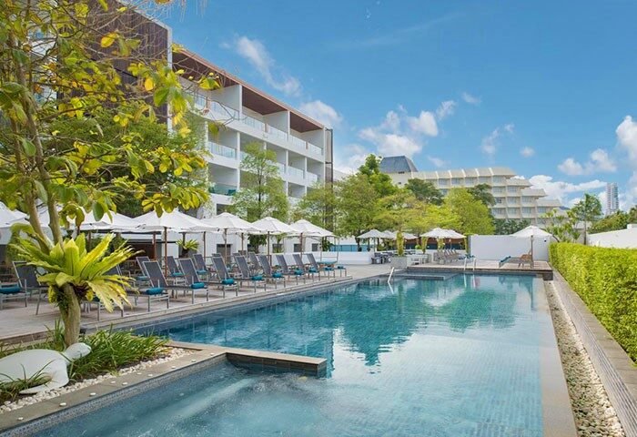 X2 Vibe Phuket Patong pool. Gay-friendly hotel in Patong, Thailand. Relaxing pool scene with loungers and umbrellas. Perfect for gay travel.