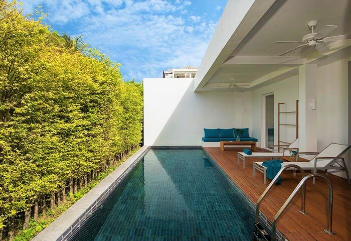 X2 Vibe Phuket Patong gay-friendly hotel pool. Modern design, lush greenery. Perfect for gay travel in Phuket, Thailand. Relaxing vibe.