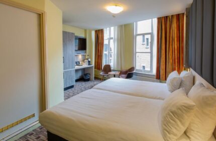 XO Hotels City Centre gay-friendly room with twin beds, desk, chairs, and city views. Comfortable stay for gay travelers in Amsterdam.