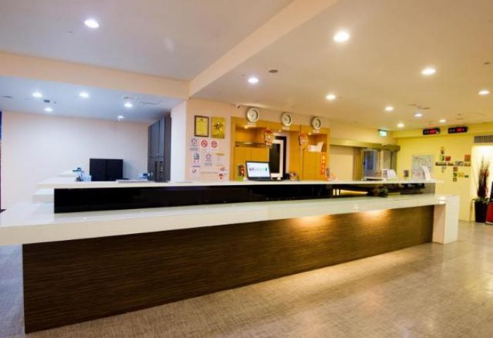 Ximen Holiday Fun Hotel's reception area. A gay-friendly hotel offering a welcoming space for travelers. Modern design, clean lines, and warm lighting.