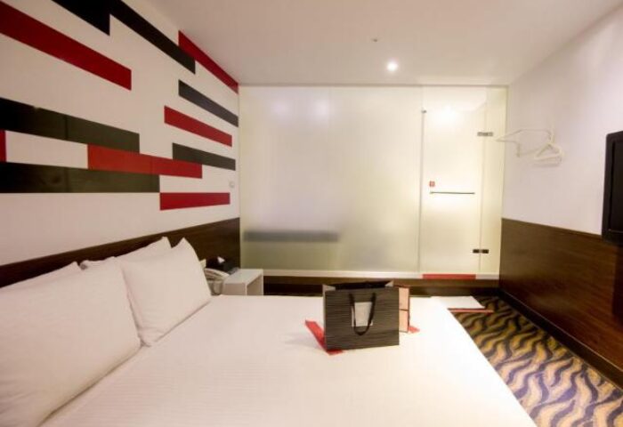 Room at Ximen Holiday Fun Hotel, a gay-friendly hotel. Modern design, white bedding, and glass-walled shower. Great for gay travelers in Ximen.