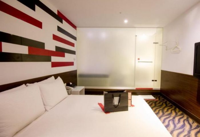 Ximen Holiday Fun Hotel room. Modern design, white bedding, and a glass-enclosed shower. Gay-friendly hotel in Ximen, Taipei for gay travelers.