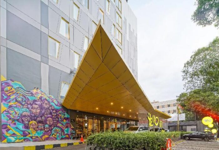 YELLO Hotel Manggarai exterior. Gay-friendly hotel with a unique triangular entrance and colorful mural. Modern design. Jakarta hotel for gay travelers.