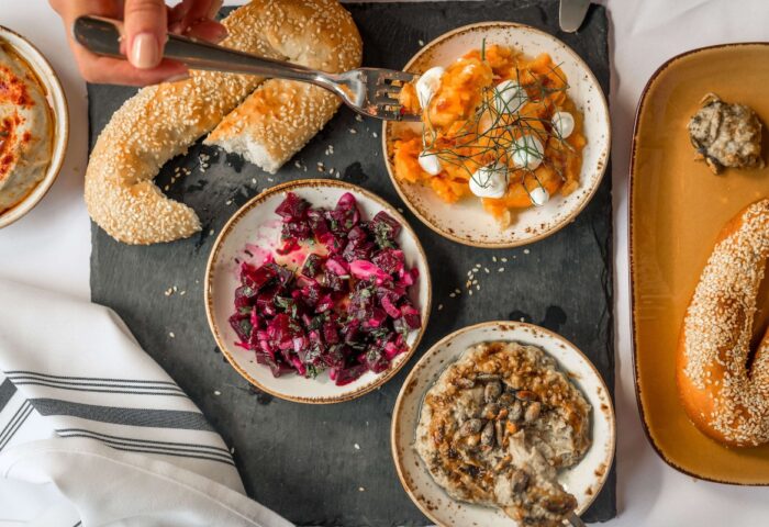 YOTEL New York Times Square gay-friendly hotel food. Mezze plates with beet salad, hummus, bread, and carrot salad on a black slate.