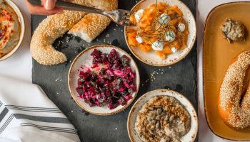 YOTEL New York Times Square gay-friendly hotel food. Mezze plates with beet salad, hummus, bread, and carrot salad on a black slate.