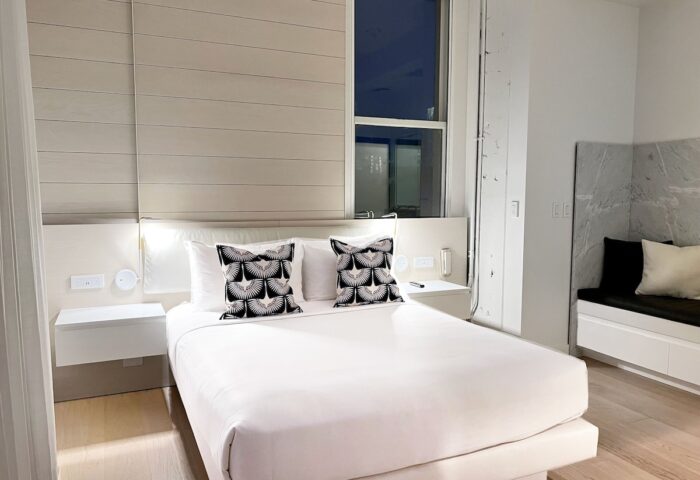 YOTEL San Francisco room. Gay-friendly hotel with a bed, pillows, and a window. Modern interior design for gay men's travel in San Francisco.