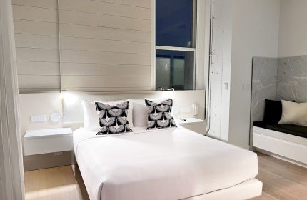 YOTEL San Francisco room. Gay-friendly hotel with a bed, pillows, and a window. Modern interior design for gay men's travel in San Francisco.