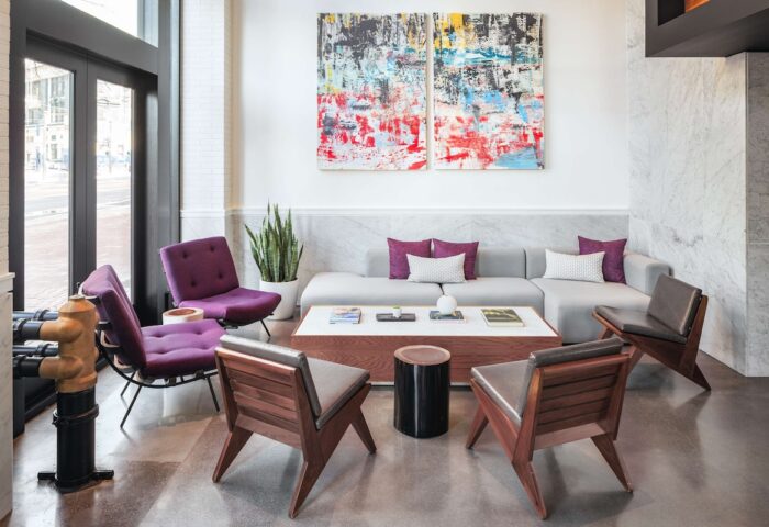 YOTEL San Francisco lobby seating area. Gay-friendly hotel with modern design, purple chairs, and abstract art. Perfect for gay travelers.