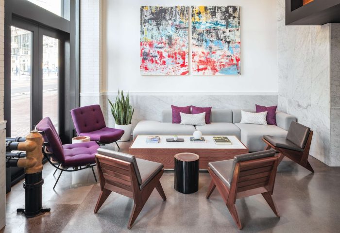 YOTEL San Francisco lobby seating area. Gay-friendly hotel with modern design, purple chairs, and abstract art. Perfect for gay travelers.