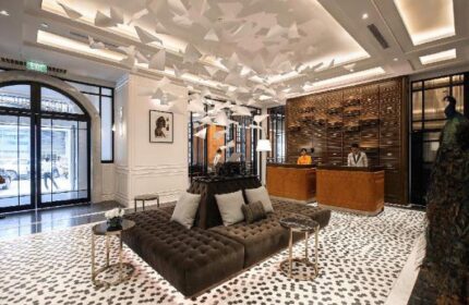 Yangon Excelsior Hotel's lobby. Gay-friendly hotel in Yangon, Myanmar. Interior with brown sofas, paper art ceiling, and reception desk.