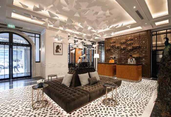 Yangon Excelsior Hotel's lobby. Gay-friendly hotel in Yangon, Myanmar. Interior with brown sofas, paper art ceiling, and reception desk.