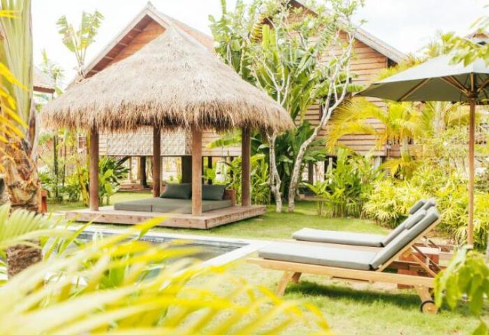 Zannier Hotels Phum Baitang: Thatched roof pavilion with daybeds, lounge chairs, and tropical greenery. A gay-friendly hotel for relaxing.