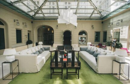 Zenit Budapest Palace hotel lobby with glass ceiling. Gay-friendly hotel in Budapest, Hungary. Modern design, sofas, and lounge area.