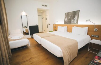 Zenit Budapest Palace gay-friendly hotel room. Twin beds with beige throws, single bed, wood floor, modern decor. A great choice for gay travelers.