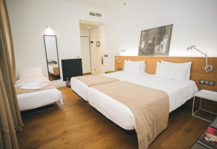 Zenit Budapest Palace gay-friendly hotel room. Twin beds with beige throws, single bed, wood floor, modern decor. A great choice for gay travelers.