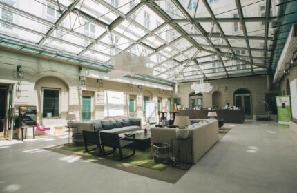 Zenit Budapest Palace lobby with glass ceiling. Gay-friendly hotel interior with sofas, chairs, and reception desk. A great choice for gay travel.