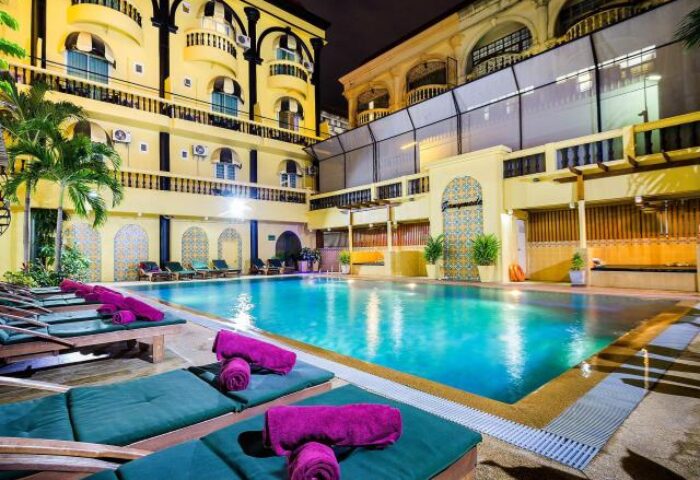 Zing Resort & Spa pool at night. Gay-friendly hotel with lounge chairs and towels. Ideal for gay men travel and relaxation.