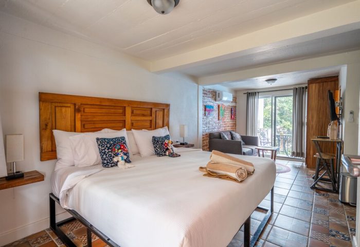 ZonaZ Boutique Hotel room. Gay-friendly hotel with bed, pillows, and sitting area. Balcony view. Gay men travel lodging.