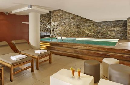 art'otel Amsterdam gay-friendly hotel pool. Indoor pool with lounge chairs, drinks, and stone wall. Gay travel advice in Amsterdam.