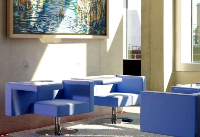 Art'otel Cologne, a Radisson hotel. Stylish seating area with blue chairs, modern art. Gay-friendly hotel design, perfect for gay travel.