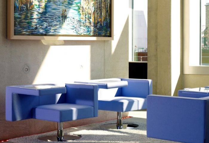 Art'otel Cologne, a Radisson hotel. Stylish seating area with blue chairs, modern art. Gay-friendly hotel design, perfect for gay travel.
