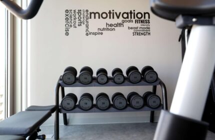 Art'otel Cologne gym, part of Radisson. Dumbbells, exercise bike, and motivational words on the wall. Gay-friendly hotel fitness center.