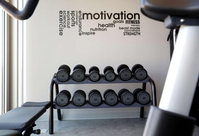 Art'otel Cologne gym, part of Radisson. Dumbbells, exercise bike, and motivational words on the wall. Gay-friendly hotel fitness center.