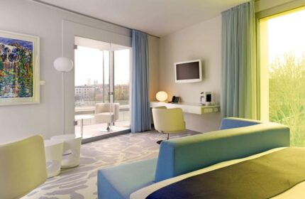 Art'otel Cologne by Park Plaza room. Gay-friendly hotel, part of Radisson Hotel Group, with modern decor, desk, and balcony for gay men travelers.