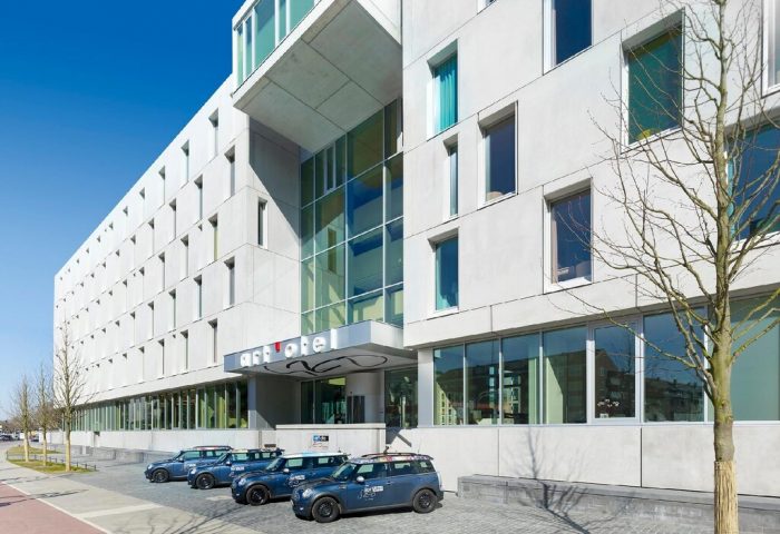 Art'otel Cologne by Park Plaza, a Radisson hotel group. Gay-friendly hotel with modern architecture and cars parked outside. Cologne, Germany.