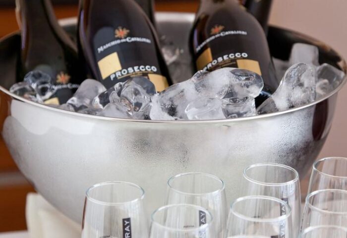 Prosecco bottles in ice bucket with glasses at carathotel Munchen City, a gay-friendly hotel. Perfect for a celebration or a gay travel event.