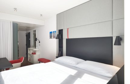 citizenM Chicago Downtown gay-friendly hotel room. Modern design with bed, desk, and bathroom. Ideal for gay men's travel in Chicago.