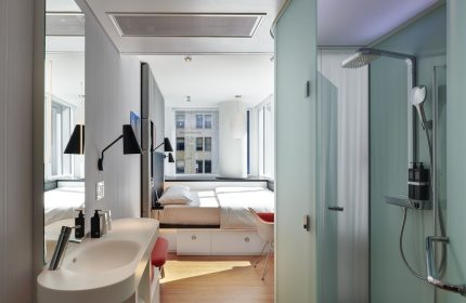 citizenM Chicago Downtown gay-friendly hotel room. Modern design with bed, sink, and shower. Great for gay men travel to Chicago.