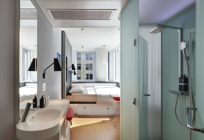 citizenM Chicago Downtown gay-friendly hotel room. Modern design with bed, sink, and shower. Great for gay men travel to Chicago.