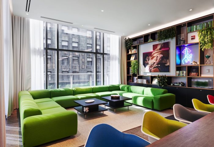 citizenM Chicago Downtown gay-friendly hotel: Modern lounge area with green sofa, colorful chairs, and city views. Stylish design.