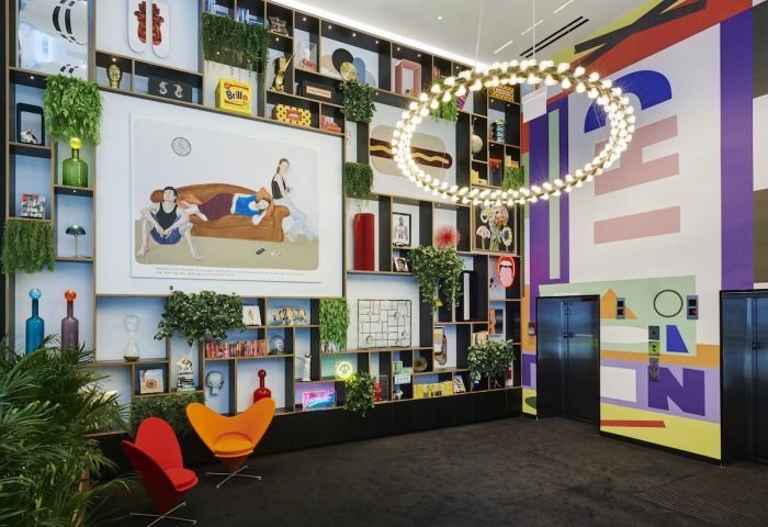 citizenM Chicago Downtown's gay-friendly hotel lobby. The interior features colorful decor, a large bookshelf, and modern design elements.