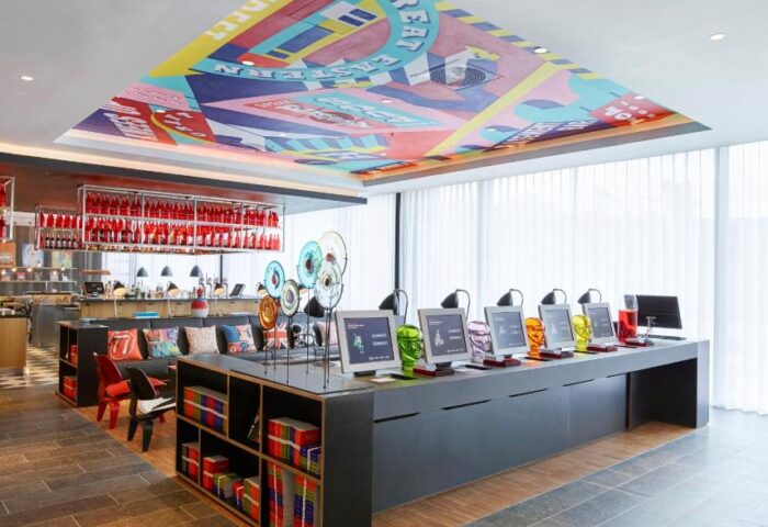 citizenM London Shoreditch's lobby. A gay-friendly hotel with colorful ceiling art, computer stations, and a bar. Great for gay travel.