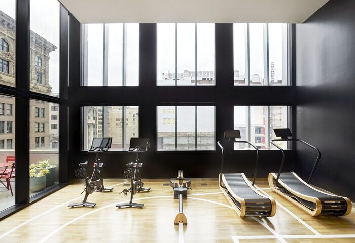 citizenM Los Angeles Downtown gay-friendly hotel gym. Exercise bikes, rowing machine, and treadmills with city view. Modern fitness for gay men.