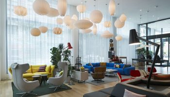 citizenM Los Angeles Downtown lobby. Modern, gay-friendly hotel with colorful seating, unique lighting, and stylish design elements.