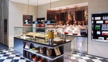 citizenM Los Angeles Downtown hotel's stylish deli area. This gay-friendly hotel features a modern design with a black-and-white checkered floor.