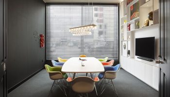 citizenM Los Angeles Downtown gay-friendly hotel meeting room. Features colorful chairs, modern lighting, and a sleek entertainment center.