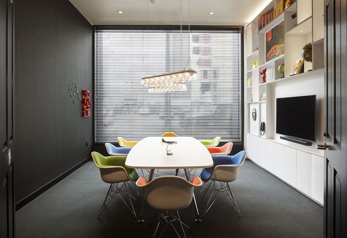citizenM Los Angeles Downtown gay-friendly hotel meeting room. Features colorful chairs, modern lighting, and a sleek entertainment center.