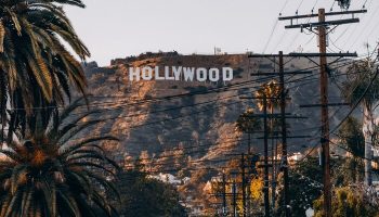 Street view of Hollywood sign from citizenM Los Angeles Downtown. Gay-friendly hotel with iconic views. Palm trees and vintage car.