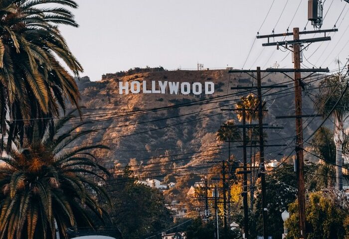 Street view of Hollywood sign from citizenM Los Angeles Downtown. Gay-friendly hotel with iconic views. Palm trees and vintage car.