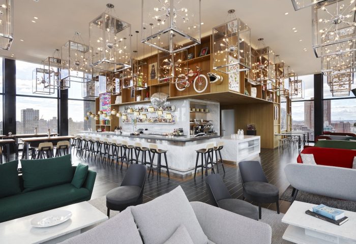 citizenM New York Bowery's stylish bar area. This gay-friendly hotel features modern decor, city views, and a vibrant atmosphere.